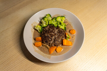 A plate of hamburg steak with vegetables.