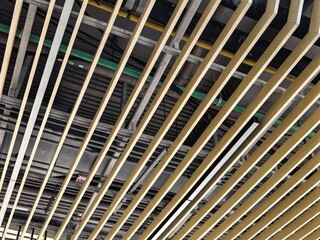 Modern Ceiling with Diagonal Wood Slats and Exposed Pipes