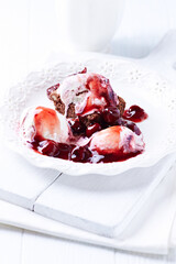 Strawberry ice cream with chocolate and cherry syrup on chocolate brownie. Selective focus.	