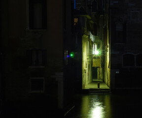 Schmale Gasse an einem Kanal in Venedig bei Nacht