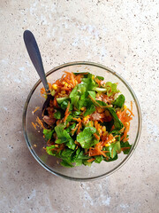fresh salad made with tuna and vegetables in bowl on stone table