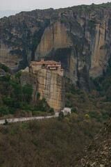 Landscape of the famous rock formations of Meteora with country road and Roussanou Monastery on top of the rocks, Kalambaka, Thessaly, Greece