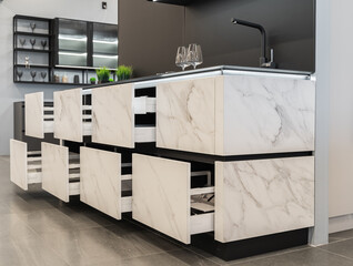 small built-in black and white kitchen. upper and lower cabinets. white countertop, black sink and...