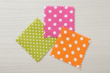 Samples of different fabrics on white wooden table, flat lay