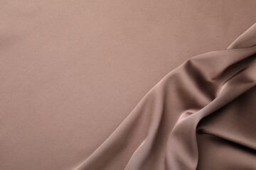 Crumpled light brown silk fabric as background, top view
