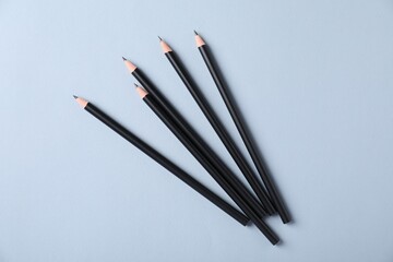 Many sharp graphite pencils on light grey background, flat lay