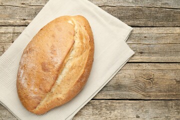 Loaf of bread on wooden table, top view
