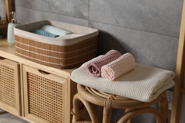Clean waffle towels on chair and dresser in bathroom, closeup