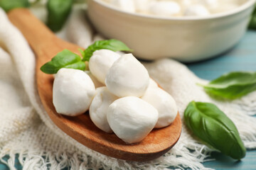 Mozzarella cheese balls and basil on blue wooden table, closeup
