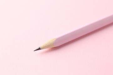 One graphite pencil on pink background, closeup