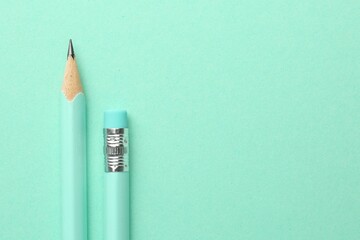 Two graphite pencils on turquoise background, top view. Space for text