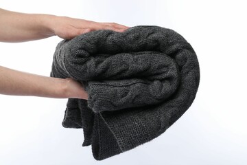 Woman with folded grey blanket on white background, closeup