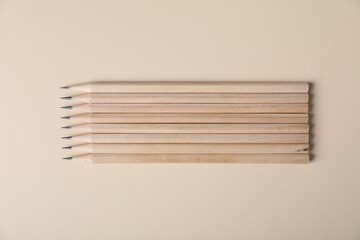 Many graphite pencils on beige background, flat lay