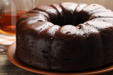 Tasty chocolate bundt cake on wooden table, closeup