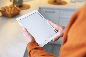 Man using modern tablet at home, closeup