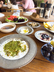 Traditional Turkish breakfast with creamy yogurt topped with ground pistachios. morning spread. local delicacies.