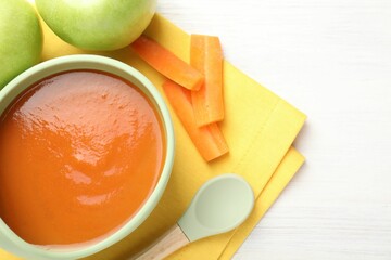Baby food. Tasty puree in bowl, different ingredients and spoon on wooden table, flat lay. Space...