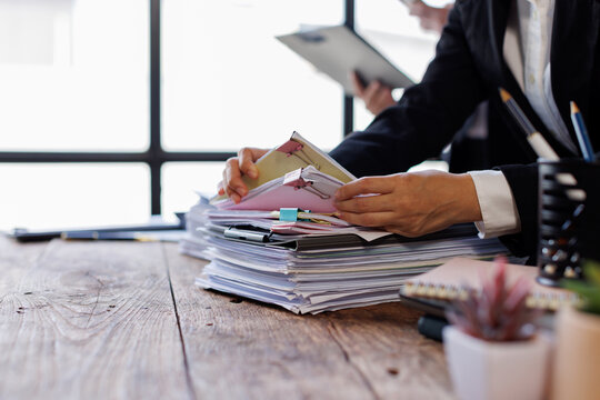 Team of Business colleagues reviewing financial documents and calculating taxes. Auditor inspecting financial reports with magnifying glass. Business audit, taxes and forensic accounting concept
