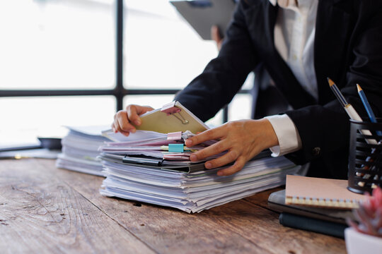 Team of Business colleagues reviewing financial documents and calculating taxes. Auditor inspecting financial reports with magnifying glass. Business audit, taxes and forensic accounting concept
