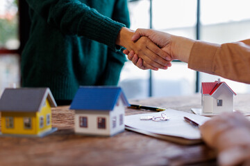 Handshake Real estate brokerage agent Deliver a sample of a model house to the customer, mortgage loan agreement Making lease and buy and sell house And contract home insurance mortgage loan concept	