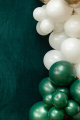 Elegant green and dark green balloons on a textured dark emerald green background. Perfect for celebrations, parties, or design backdrops with a luxurious feel.