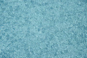 Vibrant blue water surface with shimmering reflections and ripples under sunlight