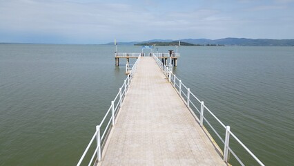 Obraz premium Europe, Italy, Umbria, drone view of Pontile Sant'arcangelo in Trasimeno lake - the landing stage for the ferries that take tourists to the larger and smaller islands - tourist attraction destination