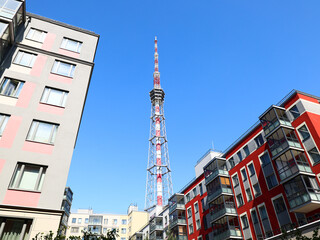 A modern cityscape with a prominent communication tower among vibrant urban architecture