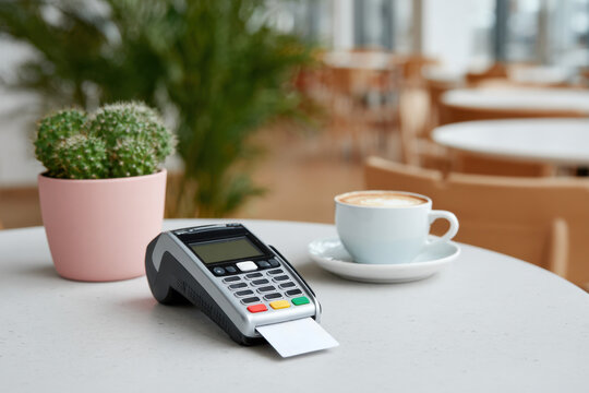 Credit card reader showing payment being processed on cafe table