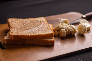 Photo of, A slice of artisanal sourdough bread with a thick spread of creamy peanut butter, Minimalist kitchen counter setting