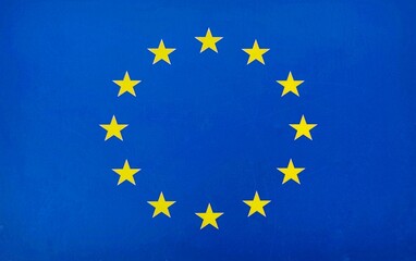 Photo of the flag of the European Union featuring a circle of twelve golden stars on a blue background, aymbolizing unity, solidarity, and harmony among the peoples of Europe.