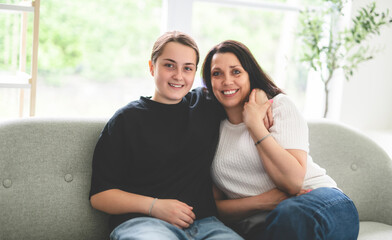 mother with teen girl, having great time on sofa