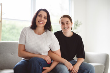 mother with teen girl, having great time on sofa