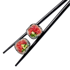 Close-up of two sushi rolls held by black chopsticks.  Fresh, raw ingredients visible