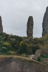 View at a rock needle at the Meteora rock formation with green forest, Kalambaka, Thessaly, Greece