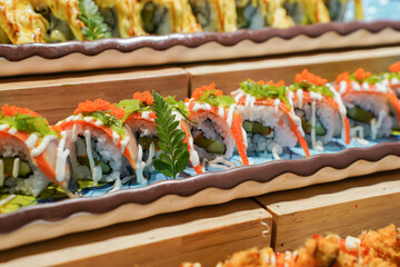 A beautifully arranged platter of maki sushi rolls, including a variety of flavors and colors served elegantly.