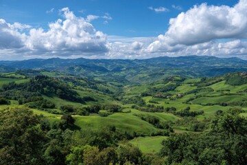 Obraz premium Rolling green hills and lush valley landscape under a blue sky
