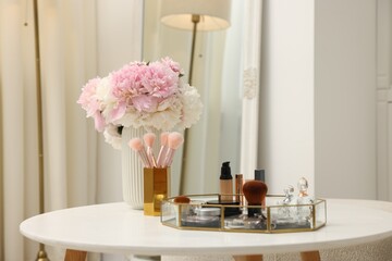 Tray with different makeup products on white table indoors. Space for text