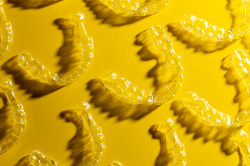 Orthodontic silicone aligner background. Advertisement of invisible braces retainer. Medical website concept. Pros and cons of aligners. Yellow saturated background