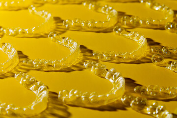 Orthodontic silicone aligner background. Advertisement of invisible braces retainer. Medical website concept. Pros and cons of aligners. Yellow saturated background