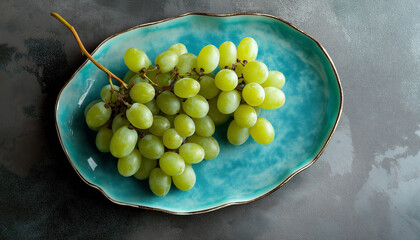 Uvas verdes frescas dispostas em um prato azul para um visual vibrante.