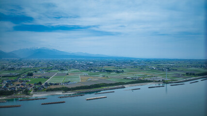 Fototapeta premium 梅雨間際で湿度の高い日本の沿岸部と離岸堤や洋上風力発電風車などの様子