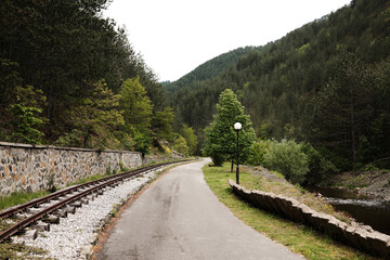 Walking path and railway track running through the scenic valley of Mokra Gora. Serbia country nature in spring season.
