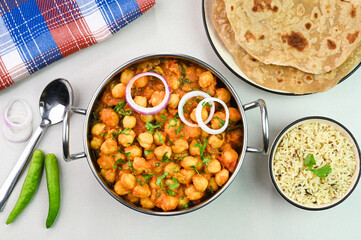 Serving chana masala dish with roti and rice.