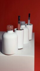 White nail polish jars lined up on a shelf with a brush