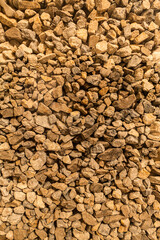 Pile of brown crushed stones, rough gravel texture, close-up