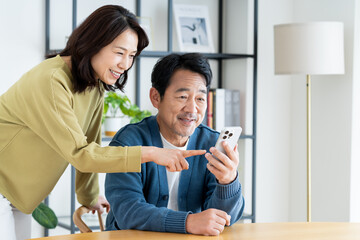 スマホを見るミドルの夫婦
