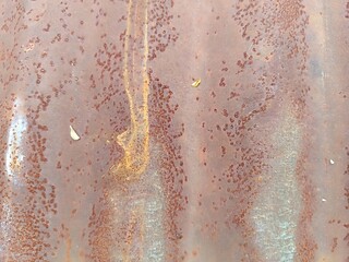 Close-up of heavily rusted corrugated metal sheet, showcasing a rich, textured surface with varying...