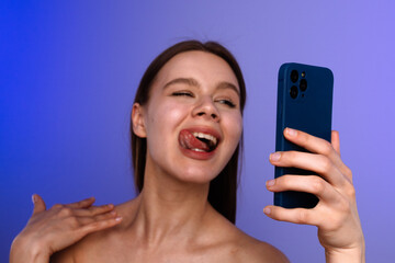 Woman Taking Playful Selfie with Blue Smartphone