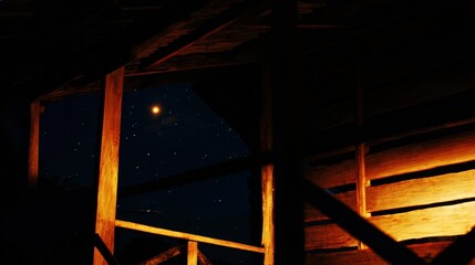 Obraz premium Serene nighttime scene featuring a warm golden-brown wooden cabin with illuminated planks and beams, casting long shadows, set against a deep blue starry sky with a bright full moon, creating a peacef